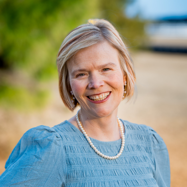 Kacey Carnegie standing on the beach and smiling at the camera
